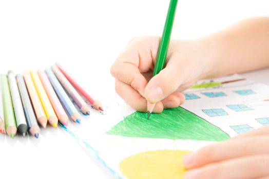 Child drawing a home with pencil