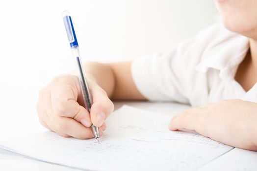 Child hands writing a homework by closeup