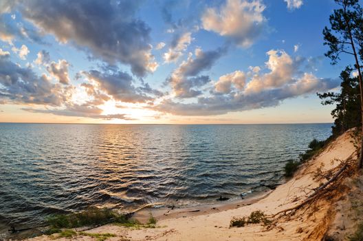 beautiful sunset over the smooth surface of a mountain lake