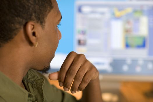 African American young adult looking at computer screen