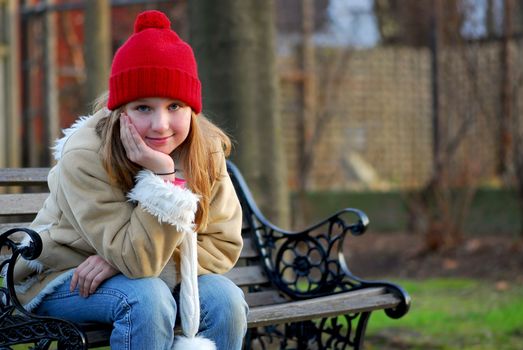 Portrait of a young girl sitting on a bench