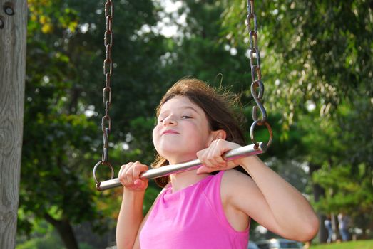 Portrait of a young girl playing on a playground at summertime
