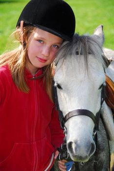 Portrait of a young girl with a white pony