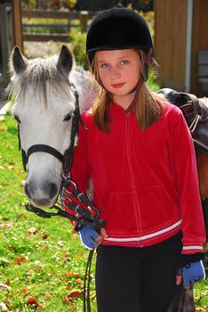Portrait of a young girl with a white pony