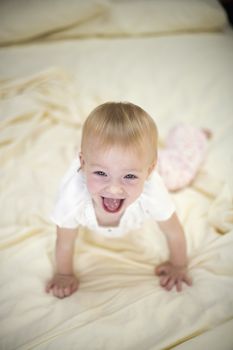 Portrait of a laughing baby girl on a bed

