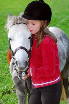 Young girl with a white pony at countryside