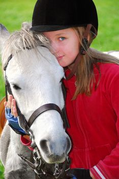 Portrait of a young girl with a white pony