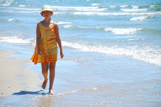 Young girl walking on a beach