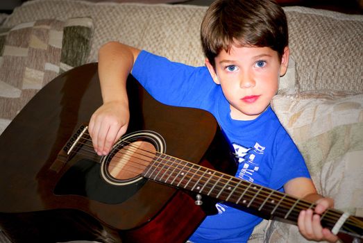Young boy playing a guitar 