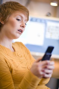 Young woman text messaging on cell phone