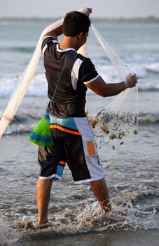 Bali, Indonesia - 27 October, 2007: The person with a network, fishing in a sunset  27 October 2007 on Bali, Indonesia.
