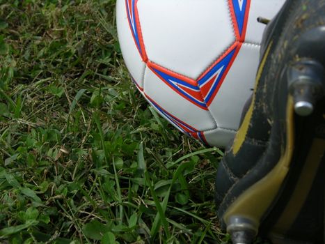 a soccer cleat on the ball ready to kick