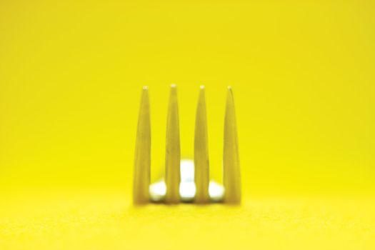 creative concept gourmet fork detail in yellow background 