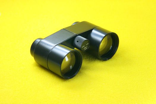 black retro binoculars from ussr in yellow background optic tools