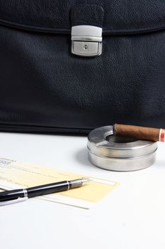 focus on cigar financial deal check writing cigar with black leather briefcase background praspective business concepts