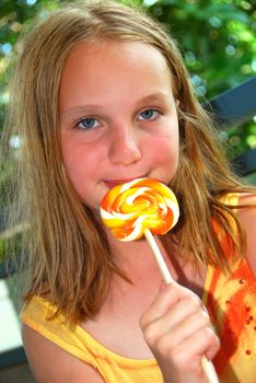 Young girl holding a big colorful lollipop candy