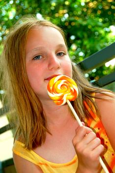 Young girl holding a big colorful lollipop candy