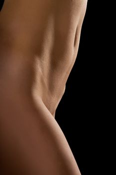 naked female body on a black background