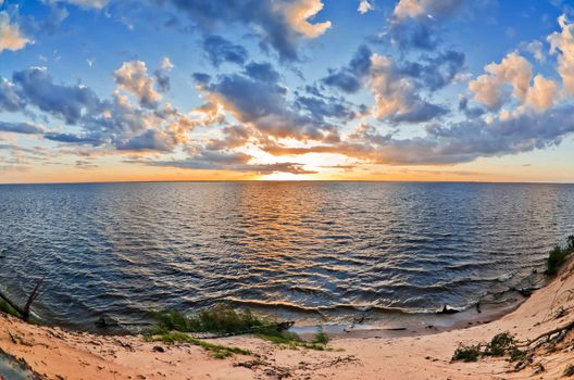 beautiful sunset over the smooth surface of a mountain lake