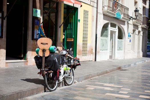 A bicycle with luggage and guitar