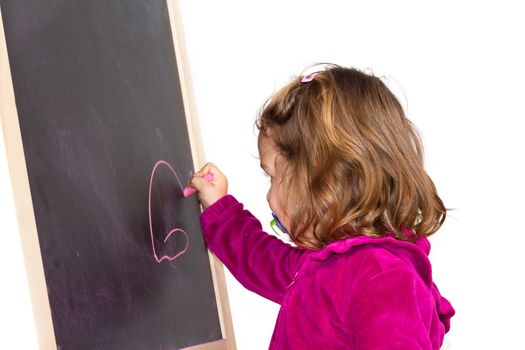 Little girl writing on a blackboard