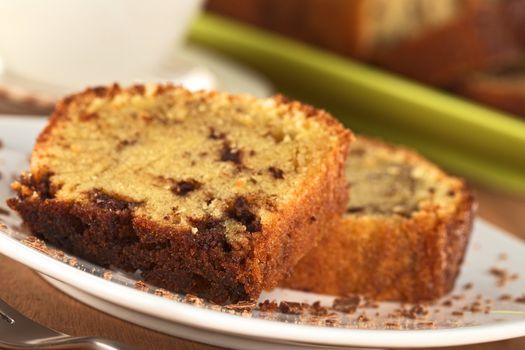 Fresh homemade slices of pound cake filled with chocolate pieces (Selective Focus, Focus on front edge of the slice)