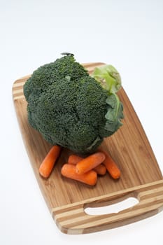 brocolli and carrots on the cutting board on the white background 