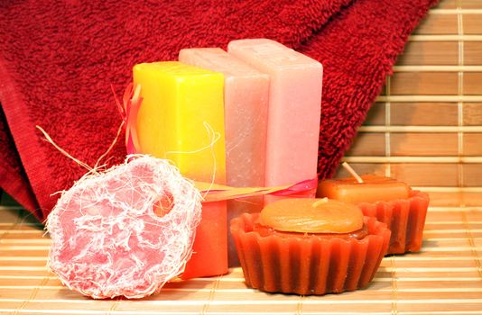 Handmade Soap, chocolate candles and red towel on the bamboo placemate closeup