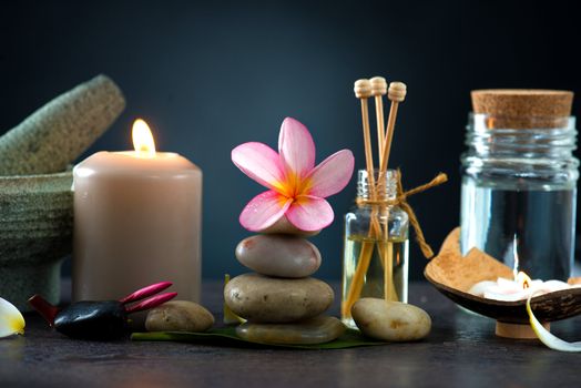 Spa concept in dark background with  ambient lights , cold stones and frangipani