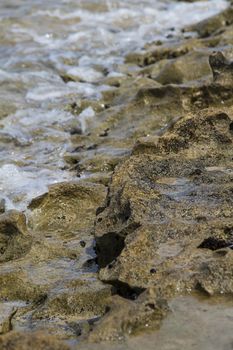 Volcanic rock shore with foaming water