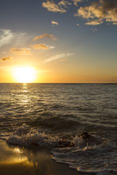 Wave crashing on the beacht at sunset