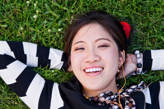 Asian woman lying on the grass in the park