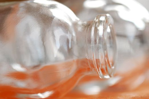 two small empty opened lass bottles  over orange background