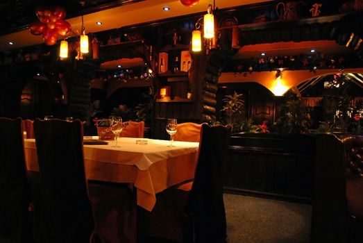 luxury rustic styled restaurant evening interior, table for dinner