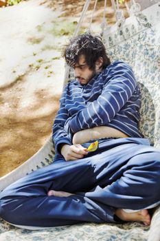 any orientation of young man with facial hair holding a fallen leaf with a distant farway expression, crop margins and negative space, soft focus, moody