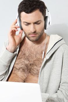 Stylish man listening to music on a gray background