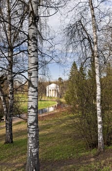 Classical rotunda view through birch trunks in early spring park