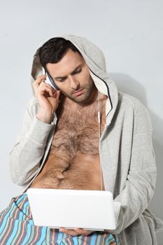 Stylish man listening to music on a gray background