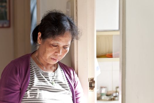 A 50s asian woman at home taking rest