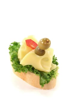 Canape with lettuce, cheese, peppers and olives