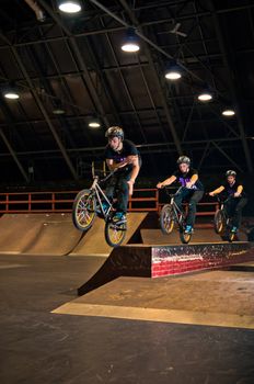 Biker doing manual to bar spin trick in park