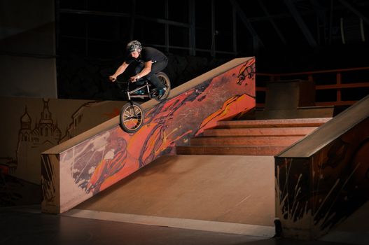 Biker doing smith grind on big grain in park