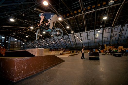 Biker doing truckdriver drop trick in wooden park