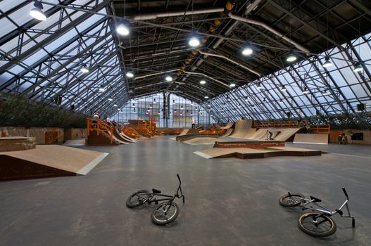 Skate park interior and bikes laying on flour in front