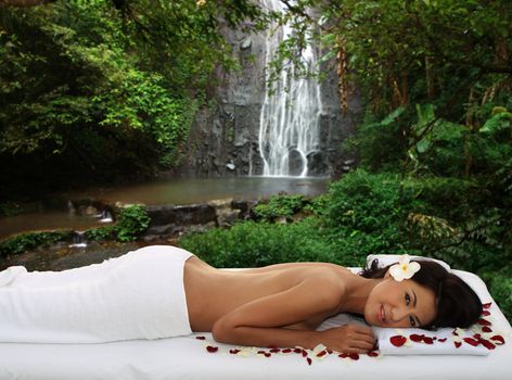 Young woman lying on a massage bed at a spa outdoors
