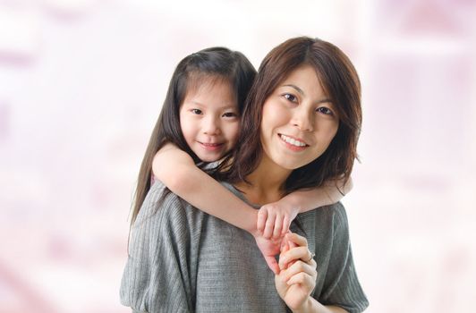 Beautiful young mother and her five years old daughter at home. Happy Asian parent and child.