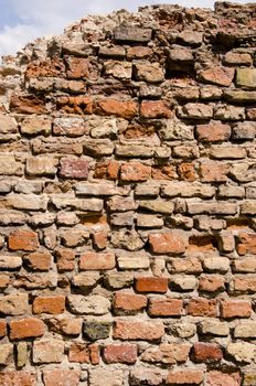 Old dilapidated brick wall backdrop of abandoned building and small patch of sky.