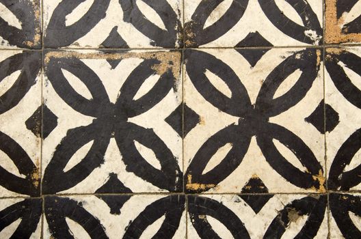 Antique floor tiles abraded backdrop in corridor.