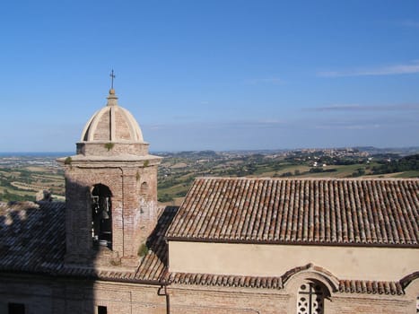 Beautiful panoramic view of fields of Italy with a high tower of the church