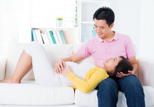Asian pregnant couple having conversation at home. Asian family living lifestyle.